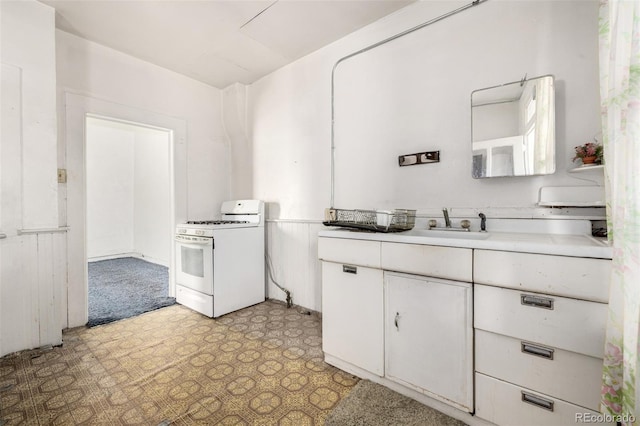 3907 Inca St Unit 3905, Denver, CO 80211 - kitchen featuring gas range gas stove, light floors, white cabinetry, and light countertops