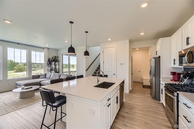 8982 Spaulding St, Parker, CO 80134 - kitchen with a sink, appliances with stainless steel finishes, open floor plan, a breakfast bar area, and white cabinetry