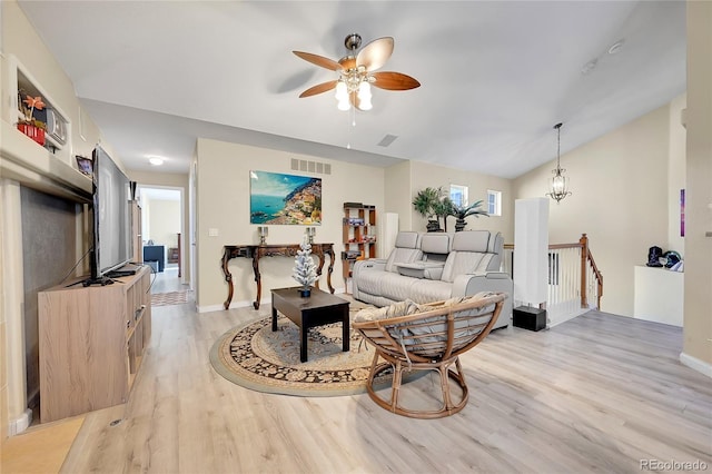 living room with ceiling fan with notable chandelier and light wood-type flooring