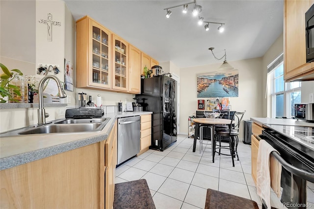 kitchen featuring light brown cabinets, black appliances, sink, hanging light fixtures, and light tile patterned floors