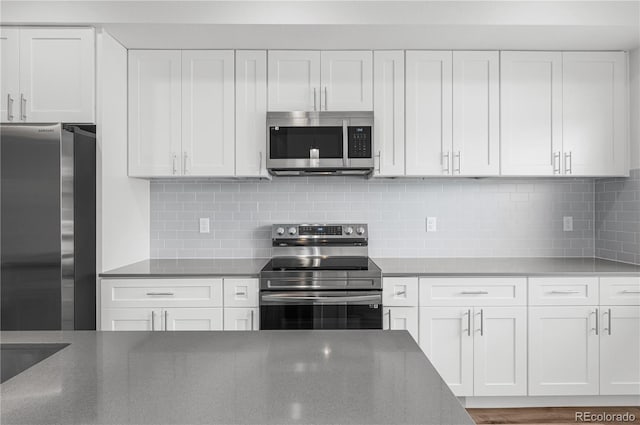 kitchen featuring stainless steel appliances, white cabinetry, and tasteful backsplash