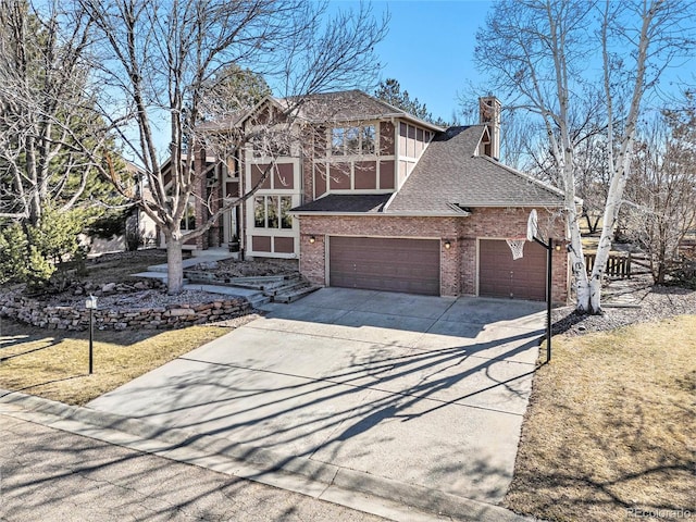 view of front of property with brick siding, concrete driveway, roof with shingles, a chimney, and an attached garage