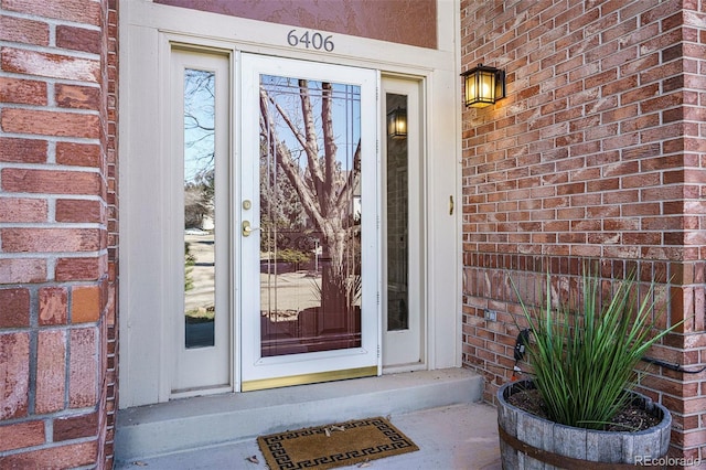 doorway to property featuring brick siding