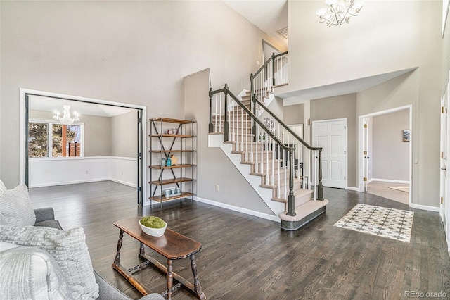 living area featuring baseboards, an inviting chandelier, wood finished floors, and stairs