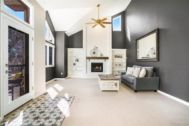 carpeted living area featuring built in shelves, high vaulted ceiling, a fireplace, baseboards, and ceiling fan