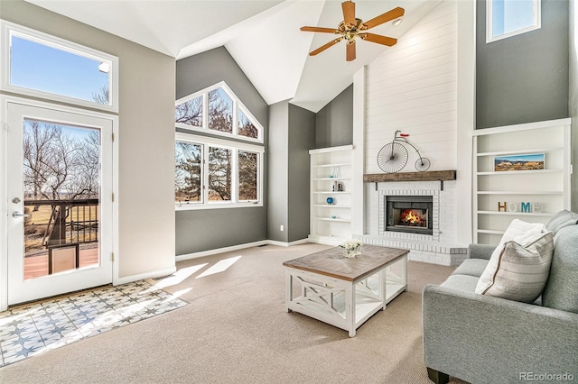 living room featuring built in shelves, baseboards, carpet floors, high vaulted ceiling, and a fireplace