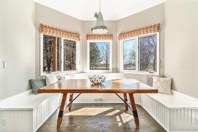 dining room with breakfast area, visible vents, and dark wood finished floors