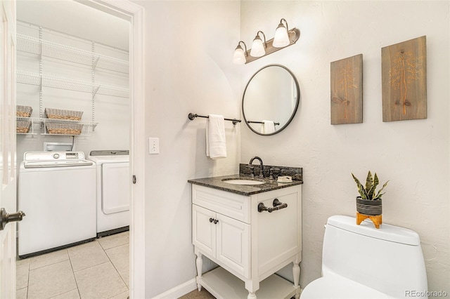 bathroom with tile patterned flooring, washer and dryer, toilet, and vanity