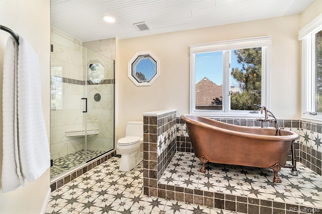 bathroom featuring visible vents, toilet, tile walls, and a stall shower