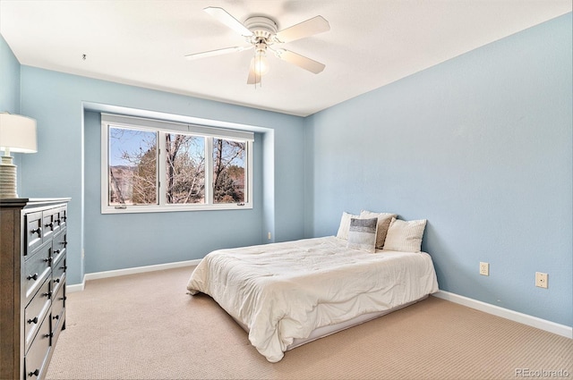 bedroom featuring baseboards, light carpet, and ceiling fan