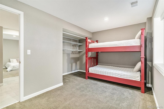 unfurnished bedroom with a closet, baseboards, visible vents, and carpet floors