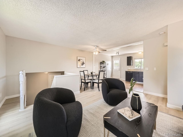 11062 Hudson Ct, Thornton, CO 80233 - living area featuring light wood-style flooring, a textured ceiling, ceiling fan, and baseboards