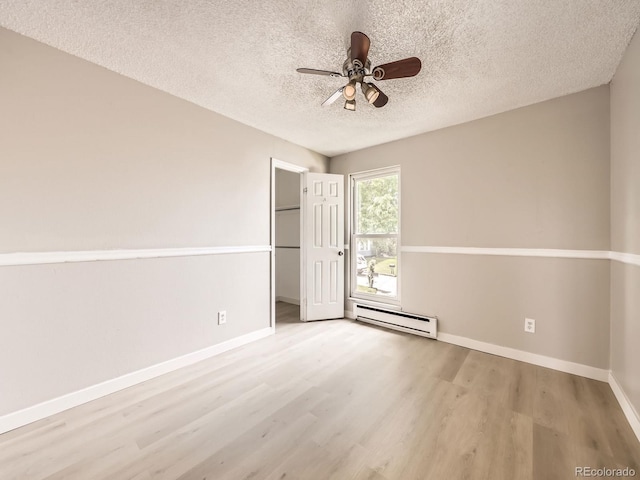 11062 Hudson Ct, Thornton, CO 80233 - spare room with a baseboard heating unit, wood finished floors, a textured ceiling, ceiling fan, and baseboards