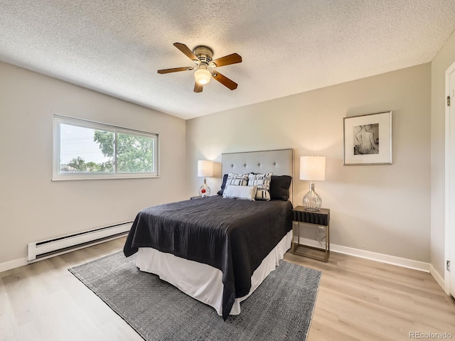 11062 Hudson Ct, Thornton, CO 80233 - bedroom with a baseboard heating unit, light wood-type flooring, a textured ceiling, baseboards, and ceiling fan