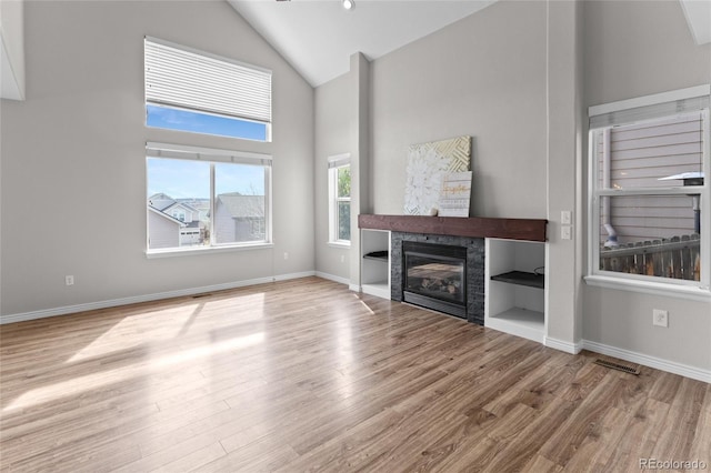 8414 Bed Straw St, Parker, CO 80134 - unfurnished living room featuring wood finished floors, a fireplace, high vaulted ceiling, and baseboards
