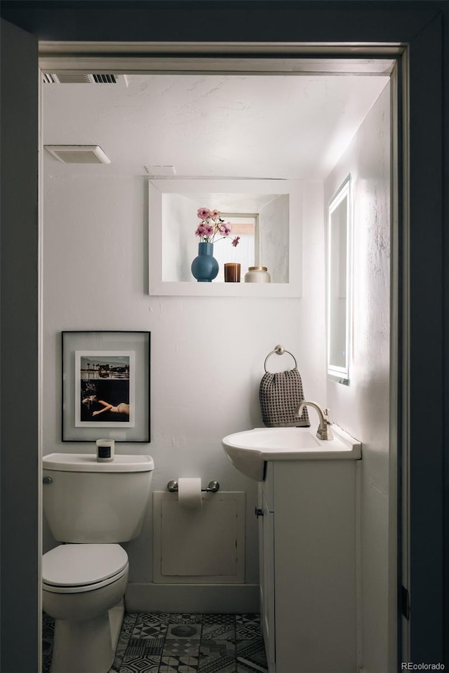 bathroom featuring tile patterned flooring, toilet, vanity, and visible vents