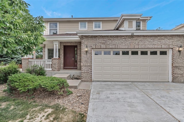 2430 S Jebel Way, Aurora, CO 80013 - view of front of property featuring brick siding, a porch, concrete driveway, and an attached garage