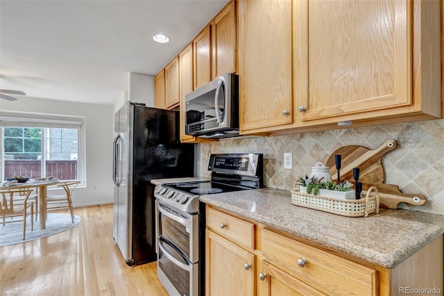 2430 S Jebel Way, Aurora, CO 80013 - kitchen featuring stainless steel appliances, decorative backsplash, light wood-type flooring, light stone countertops, and ceiling fan