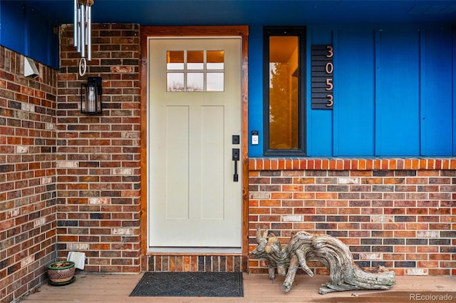 3053 Mcintosh Dr, Longmont, CO 80503 - doorway to property with board and batten siding, brick siding, and a porch