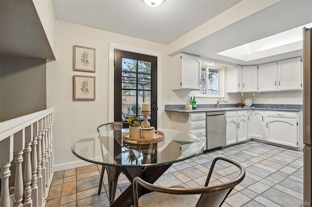 3053 Mcintosh Dr, Longmont, CO 80503 - kitchen featuring stainless steel dishwasher, plenty of natural light, and white cabinets