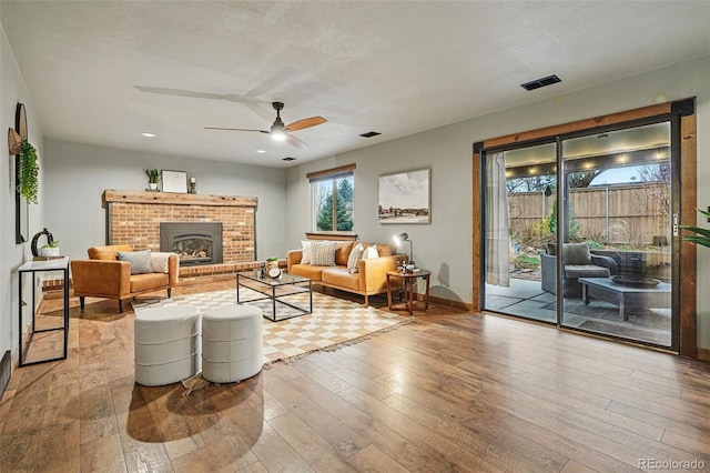 3053 Mcintosh Dr, Longmont, CO 80503 - living area with wood-type flooring, ceiling fan, a brick fireplace, and recessed lighting