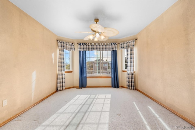 unfurnished room featuring carpet flooring, baseboards, and ceiling fan