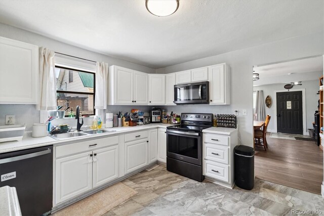 330 2nd St, Kersey, CO 80644 - kitchen with stainless steel appliances, a sink, white cabinetry, and light countertops