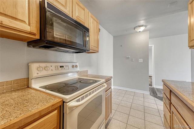 kitchen featuring white electric stove, light tile patterned floors, light brown cabinets, black microwave, and baseboards