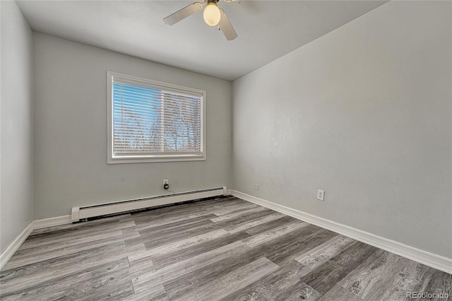 empty room featuring light wood finished floors, a baseboard radiator, and baseboards