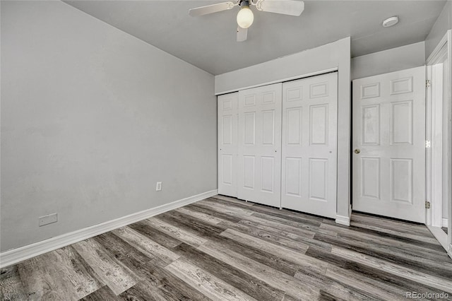 unfurnished bedroom with a ceiling fan, a closet, baseboards, and wood finished floors