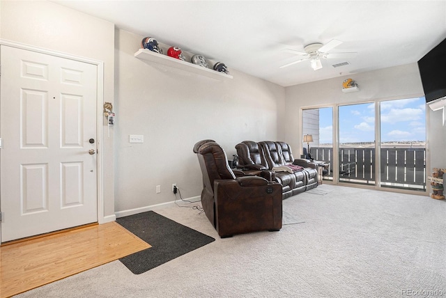 carpeted living room with baseboards, visible vents, and a ceiling fan