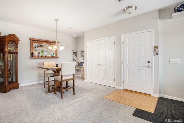 carpeted dining room with baseboards