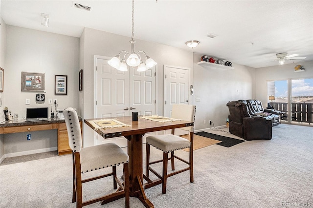 dining area with visible vents, built in study area, light carpet, and baseboards