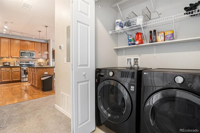 laundry area featuring laundry area, visible vents, light colored carpet, and washing machine and clothes dryer