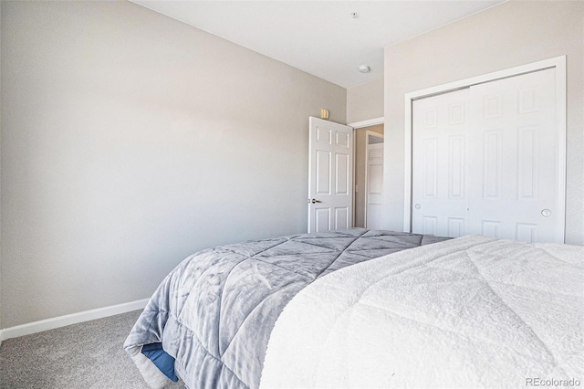 carpeted bedroom featuring baseboards and a closet