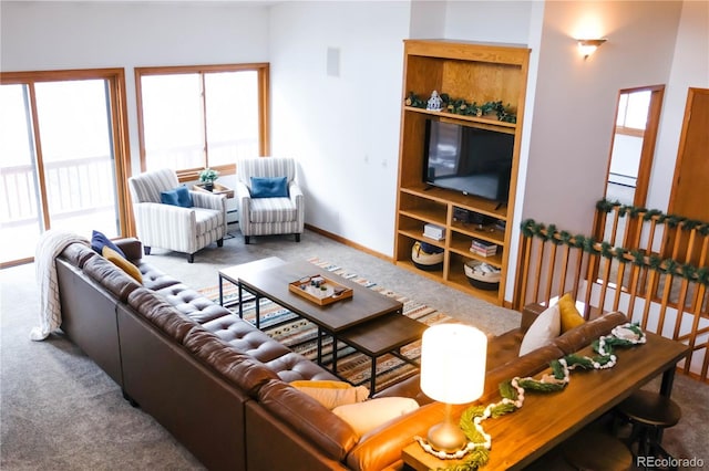 living room with a wealth of natural light, baseboards, and carpet floors