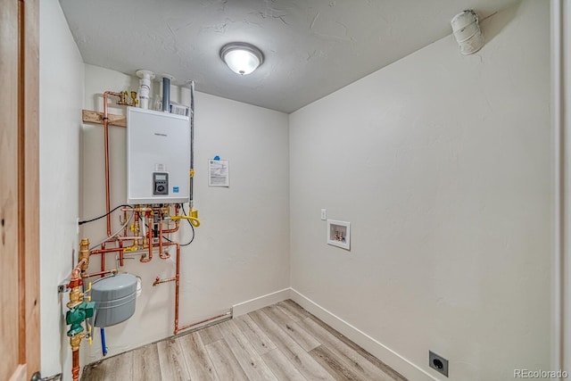 880 Hoover Cir, Poncha Springs, CO 81242 - laundry room featuring baseboards, wood finished floors, laundry area, water heater, and hookup for an electric dryer