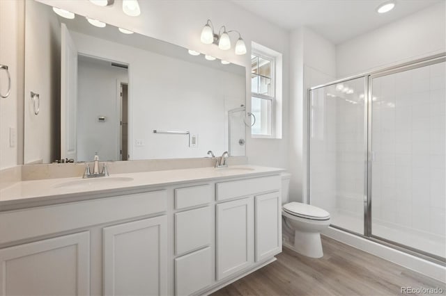 24780 E 39th Ave, Aurora, CO 80019 - full bathroom featuring a stall shower, wood finished floors, toilet, double vanity, and recessed lighting