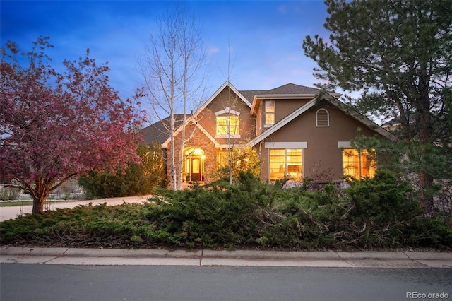 view of front of home featuring stucco siding and stone siding