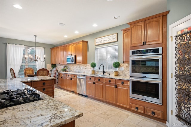 kitchen featuring plenty of natural light, stainless steel appliances, tasteful backsplash, and a chandelier
