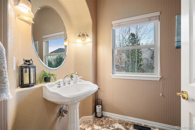 bathroom with a healthy amount of sunlight, baseboards, and visible vents