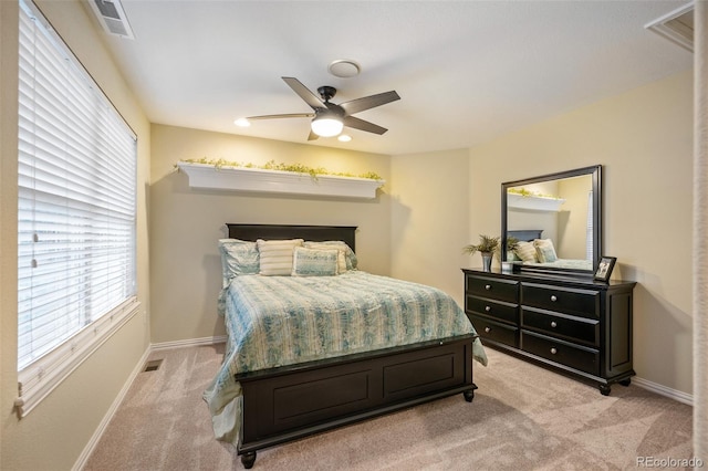 bedroom with baseboards, visible vents, light carpet, and ceiling fan