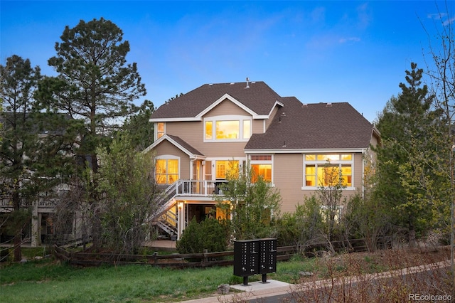traditional-style home with a shingled roof and stairway