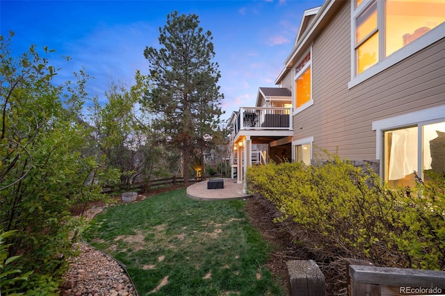 view of yard featuring a wooden deck, a patio, and an outdoor fire pit