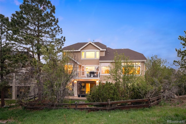 view of front of property featuring fence and a balcony