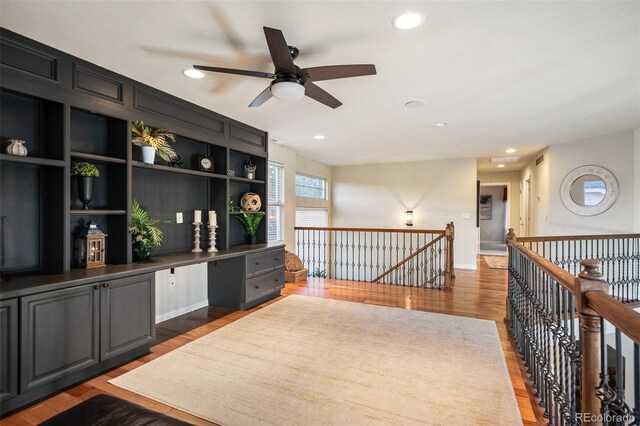 7284 Timbercrest Ln, Castle Pines, CO 80108 - living area with an upstairs landing, wood finished floors, built in study area, a ceiling fan, and recessed lighting