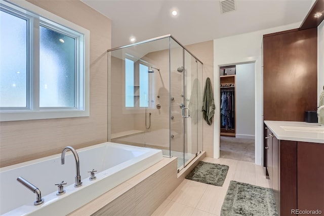 bathroom with tile patterned flooring, vanity, and plus walk in shower