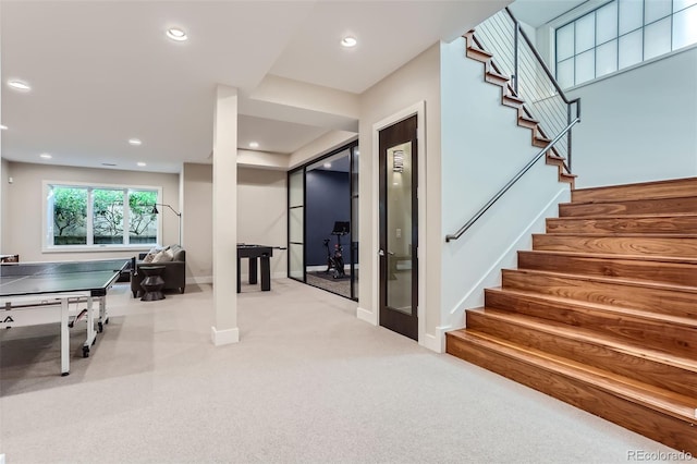 recreation room featuring light carpet