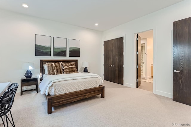 bedroom with light colored carpet and connected bathroom