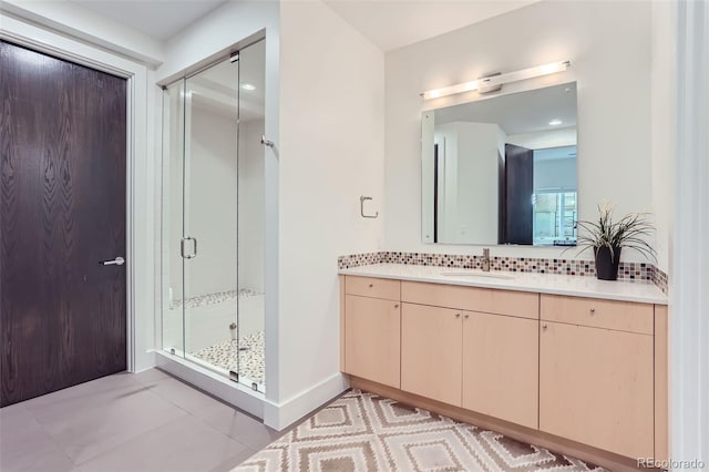 bathroom with tile patterned flooring, vanity, tasteful backsplash, and a shower with shower door